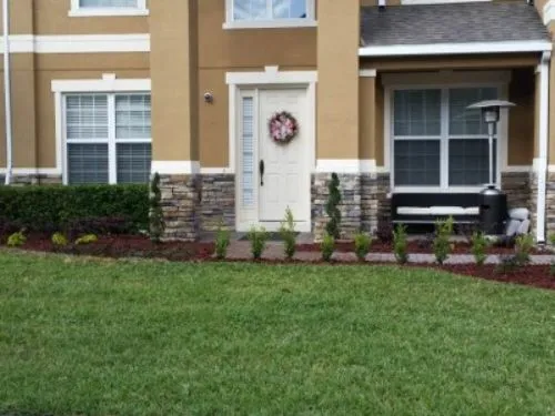 Sod lawn in front of a townhome entry with stone accents